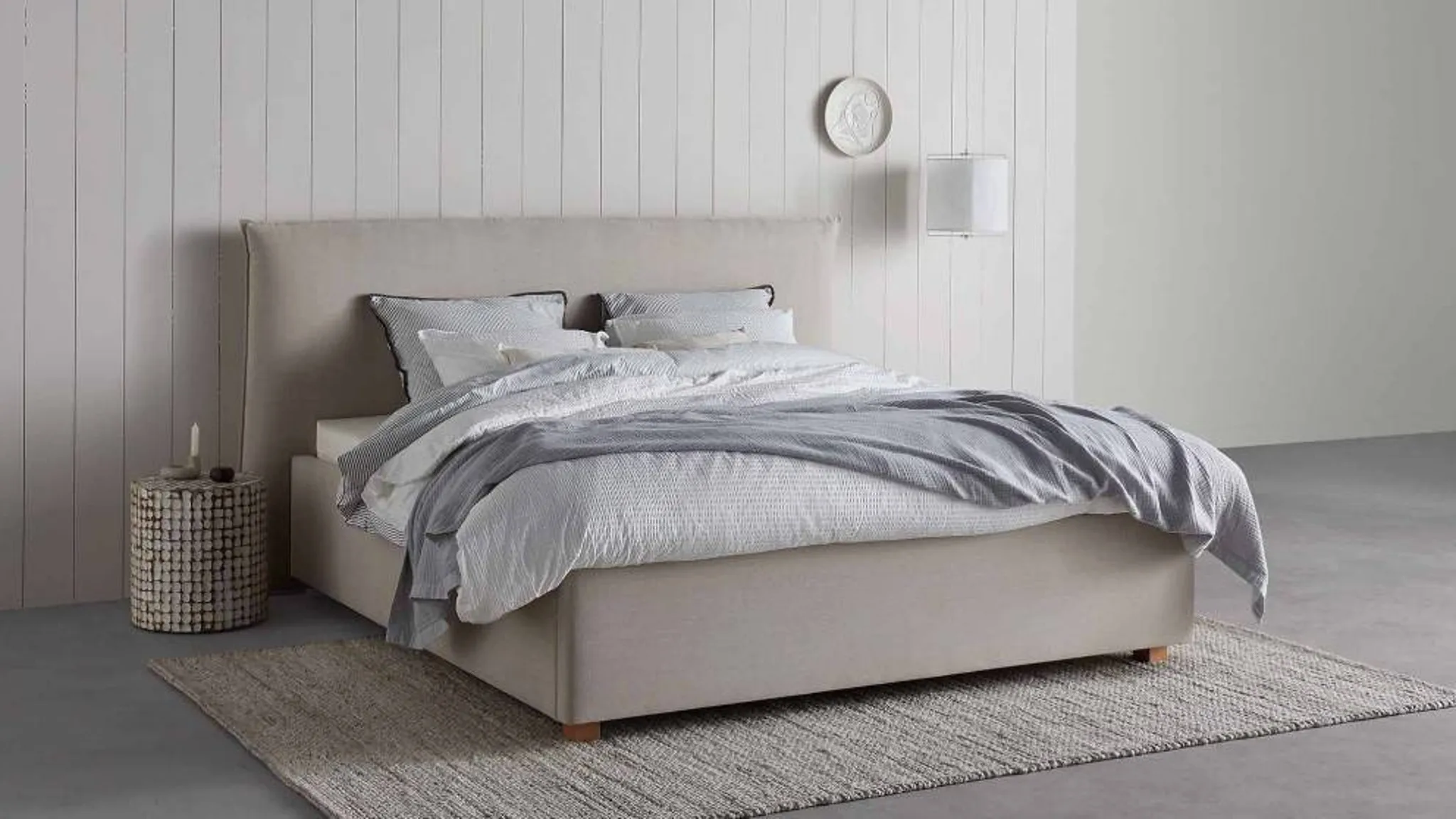 Modernes Polsterbett mit hohem Kopfteil in einem Schlafzimmer